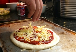 Sprinkling cheese on pizza